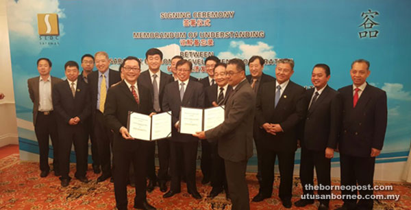 Johari (middle right front) lines up with State Secretary Morshidi Abdul Ghani to sign the deal